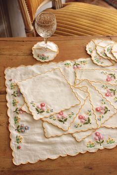 the table is set with four placemats and two wine glasses on top of it