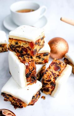 several pieces of cake sitting on top of each other next to a cup of coffee