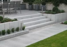 an outdoor patio with concrete steps and planters