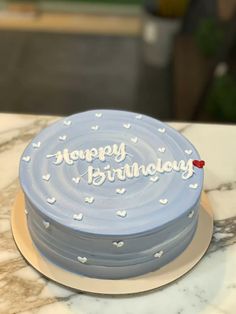 a blue birthday cake sitting on top of a table