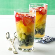 two glasses filled with fruit on top of a table