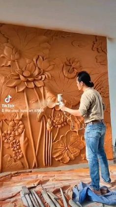 a man painting a wall with flowers on it