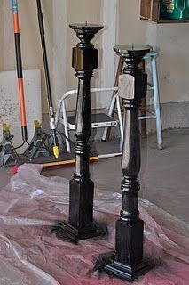 two black candlesticks sitting on top of a pink cloth covered floor next to a wall