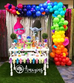 the table is set up with balloons and decorations