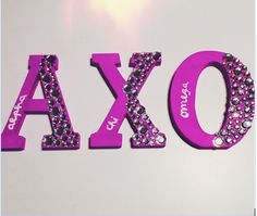 the letters are made up of pink and purple crystals, which spell out the word axxo