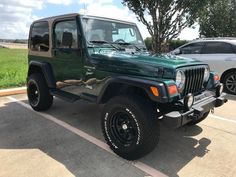 a green jeep parked in a parking lot