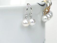 "Gleaming, white freshwater pearls dangling from sterling silver French ( or Leverback ) ear wires. Classic 7mm near round pearls with high luster and smooth surface. Simply elegant pearl earrings, great for everyday wear as well. Pearls are approx. 7 - 7.15mm, near round, with high luster and smooth surface ( minor natural imperfection ). - Earrings measure 13/16\" ( 2.1 cm ) with French Ear wires, and just over1\" ( 2.6cm ) with leverbacks. ✤ Earrings in 14k gold filled: https://www.etsy.com/l Adjustable White Pearl Earrings For Anniversary, White Pearl Earrings For Wedding With Lever Back, Hypoallergenic Round Pearl Beads Earrings For Wedding, Delicate Nickel-free Round Pearl Earrings, Elegant Nickel-free 14k Gold Filled Pearl Earrings, Nickel-free White Pearl Earrings In 14k Gold, 14k Gold-filled Pearl Drop Earrings In Pearl White, Elegant 14k Gold-filled Pearl White Pearl Earrings, Ivory Earrings