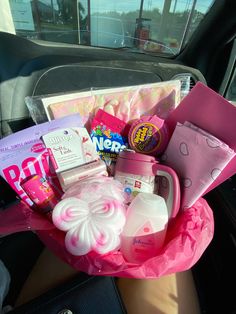 a pink car filled with lots of different types of items in the passenger side seat