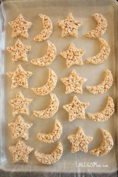 an uncooked cookie sheet with stars and moon shaped cookies on it, ready to go into the oven