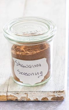 a glass jar filled with cinnamon spice sitting on top of a wooden board