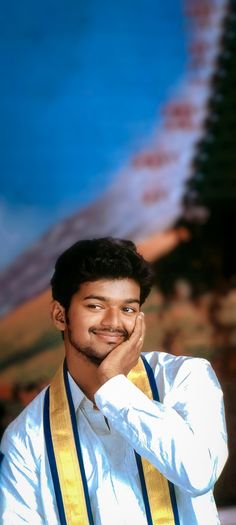 a man in white shirt and yellow tie posing for the camera with his hand on his chin