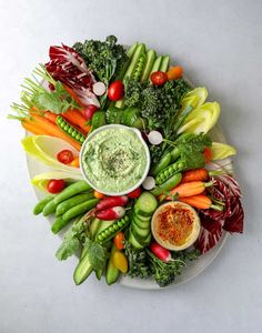 a white plate topped with vegetables and dip