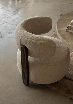 a chair sitting next to a table with a book on it