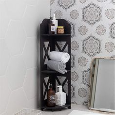 a shelf with towels and soaps on it next to a bathroom wallpaper pattern