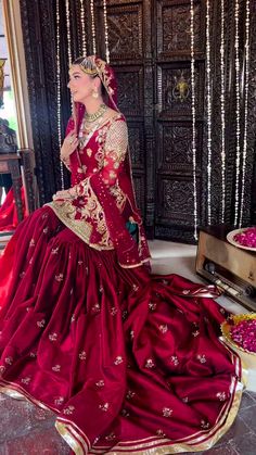 a woman in a red and gold wedding dress