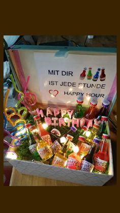 a box filled with lots of different types of drinks and confetti on top of a table