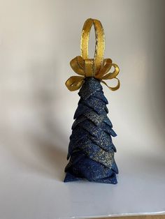 a small blue cone shaped ornament with gold ribbon