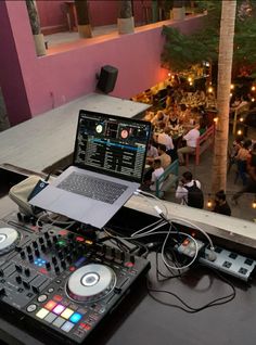 a laptop computer sitting on top of a dj's deck