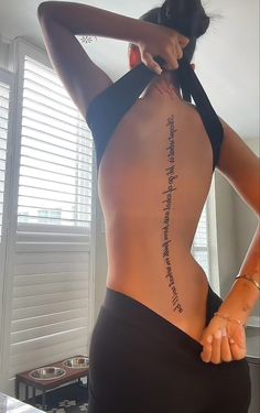 the back of a woman's body with words written on it and her hands behind her head