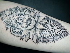 a black and white photo of a flower on someone's left arm with intricate lacework