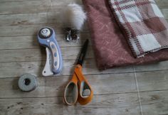 some scissors and other items are laying on the floor next to each other, along with a towel