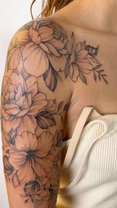 a woman's arm with flowers on it, and the back of her shoulder