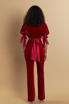 This stylish Bow Tie Sleeve Velvet Jumpsuit exudes sophistication. It is crafted from luxuriously soft velvet with contrasting satin at the sleeves and waist tie. With a slim fit a deep V-neckline and a waist belt it is tailored to flatter the feminine figure. With its luxurious and unique design, this jumpsuit is designed to make you look chic and make a fashion statement. Velvet Satin contrast at sleeve and waist tie Slim fit Deep v neckline Puff short sleeves Back zipper Long length pants Sid Chic Velvet Jumpsuits And Rompers, Velvet Jumpsuits And Rompers For Party, Elegant Jumpsuits With Belted Cuffs, Fitted Jumpsuits And Rompers With Tie Waist For Party, Evening Fitted Jumpsuits And Rompers With Tie Waist, Fitted Belted Jumpsuits And Rompers For Date Night, Fitted Velvet Jumpsuits And Rompers For Party, Fall Fitted Jumpsuits And Rompers With Tie Waist, Fitted Fall Jumpsuits And Rompers With Tie Waist