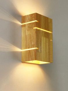 a wooden wall light with two lights on it's sides and one is turned on