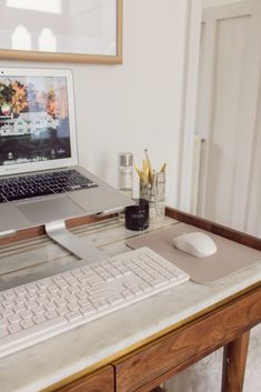 an open laptop computer sitting on top of a desk next to a keyboard and mouse