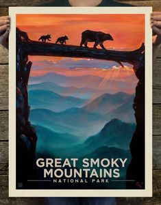 a person holding up a poster with two bears on top of a tree branch in the mountains