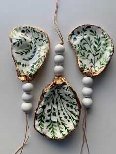 three pieces of porcelain with beads and leaves on them