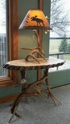 a lamp that is sitting on top of a tree branch table in front of a window