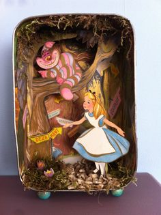 a tinker box with an alice in wonderland scene