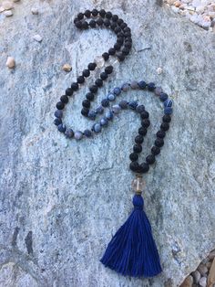 Long beaded mala style necklace 41 inches in length Made of lava rock beads (10mm), black cracked agate stone beads (10mm), quartz beads (14mm), spaced by black Czech glass seed beads. this mala is finished with a quartz stone & a 100% Egyptian cotton tassel. Please take a few moments to browse through my shop .... I have a large variety of unique belt buckles , leather belt straps, beaded key chains and jewelry. Orders will arrive lovingly packaged and tied with ribbon. Thank you for visiti Bohemian Black Hand Knotted Jewelry, Adjustable Agate Mala With 8mm Beads, Bohemian Jewelry With Natural Lava Stones, Black Hand-knotted Jewelry With Round Beads, Adjustable Black Hand Knotted Necklace, Black Hand Knotted Adjustable Necklace, Beaded Key Chains, Lava Stone Necklace, Long Stone Necklace