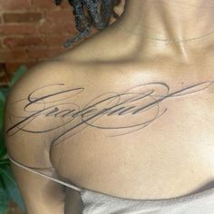 the back of a woman's shoulder with some writing on her left arm and chest