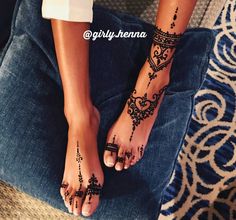 a woman's feet with henna tattoos on them