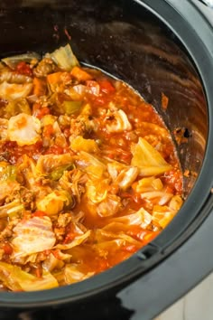 a slow cooker filled with meat and vegetable stew, ready to be cooked in the crock pot