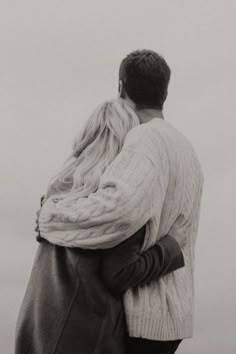 a man and woman embracing each other on the beach