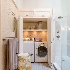 a washer and dryer sitting inside of a bathroom next to a walk in shower