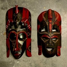 two red and brown masks are hanging on the wall