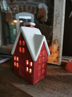 a red and white house shaped tea light holder