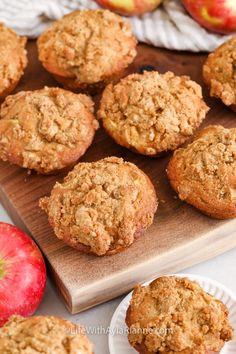 muffins on a cutting board with apples in the background