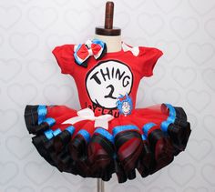 a red thing 2 dress with black and blue ruffles on the bottom that says thing 2