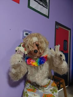 a large stuffed animal sitting on top of a chair in front of a purple wall