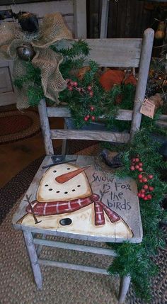 two wooden chairs decorated with christmas decorations and wreaths, one is made to look like a snowman