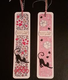 two bookmarks with cats and flowers on them are hanging from twine stringes