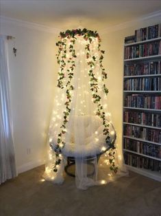 a room with bookshelves and lights on the wall, decorated with greenery