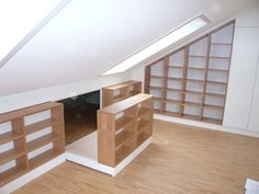 an empty room with wooden shelves and white walls