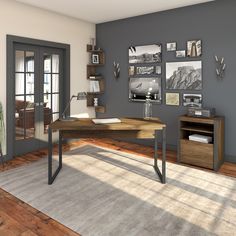 a computer desk sitting on top of a hard wood floor next to a book shelf