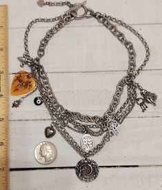 This is a Vintage Six intertwined  Strand of Stainless Steel Mixed size Multi Chain Choker Necklace with various Whimsical Charms- Known lovingly as a NECKMESS ; a LUCKY guitar pick, ladybug, black evil eye, heart, Om, Hamsa, keys on a tiny ring, lady with Chain link movable skirt and the bottom drop Charm is round with a Crescent Moon surrounded by trees.  This special Necklace is a more Oxidized Silver and a Toggle Clasp.  This is a truly unique and one of a Kind design.  *PLEASE NOTE DO NOT SUBMERGE YOUR JEWELRY IN WATER OR WEAR WHILE SLEEPING * Black Evil Eye, Charm Necklace Diy, Recycled Necklaces, Tiny Rings, Special Necklace, Necklace Diy, Hozier, Chain Choker Necklace, Oxidized Silver